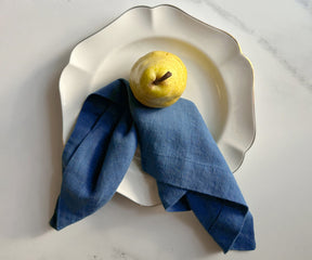 Close-up view of several folded blue linen napkins, suggesting a clean and elegant table setting.