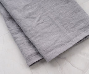 Set of 2 gray linen dish towels beside ceramic sink