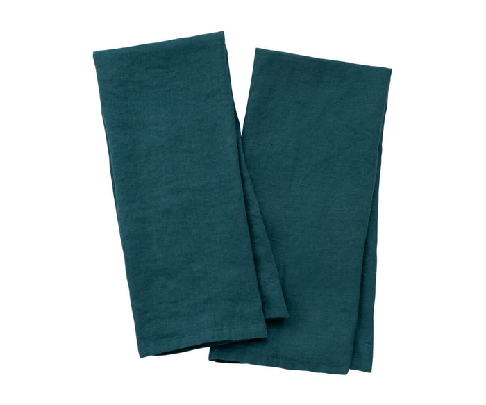 Folded green kitchen towels stacked on marble countertop