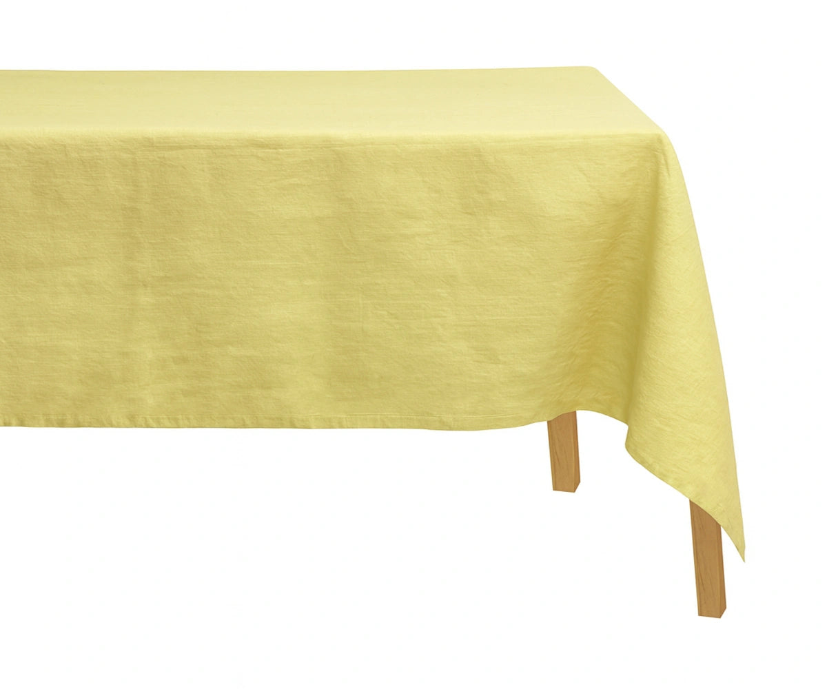 Butter yellow 100% linen rectangular tablecloth displayed on a dining table, adding a soft and elegant touch to the setup.