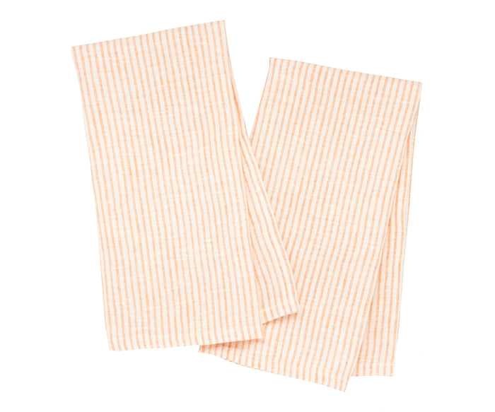 Orange and white linen striped towels hanging on a hook in a farmhouse-style kitchen