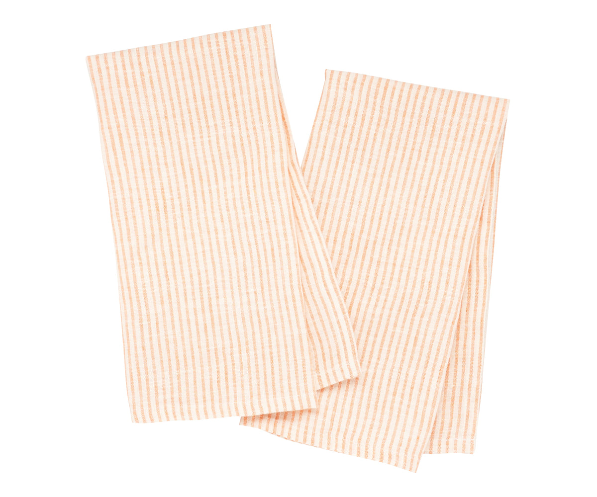 Orange and white linen towels hanging on a hook in a farmhouse-style kitchen