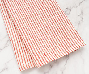 Rustic kitchen décor featuring red striped linen towels hanging on a hook