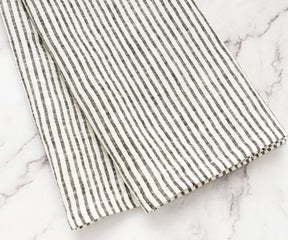 Elegant black striped linen towels used as decorative accents in a rustic kitchen