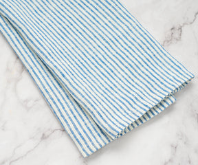 Lightweight and breathable linen tea towel with blue stripes draped over the sink