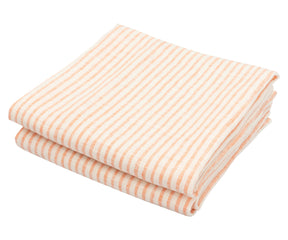 Orange striped dish towel draped over a sink with fresh produce nearby