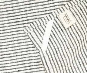 Linen tea towels with classic black stripes draped over a sink