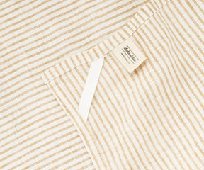Stacked natural stripe linen towels styled with ceramic kitchenware