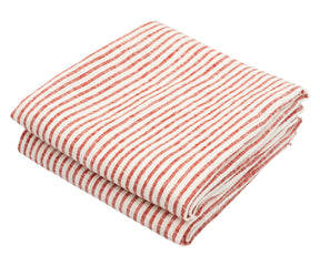 Stacked red and white linen towels beside baking ingredients