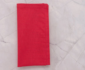 Reusable maroon cotton napkins stacked neatly, perfect for home or event use.