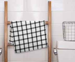 Black and white plaid towel hanging outdoors on a washing line