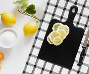 Hand towel with black and white checkered design used as a backdrop for lemons and sugar