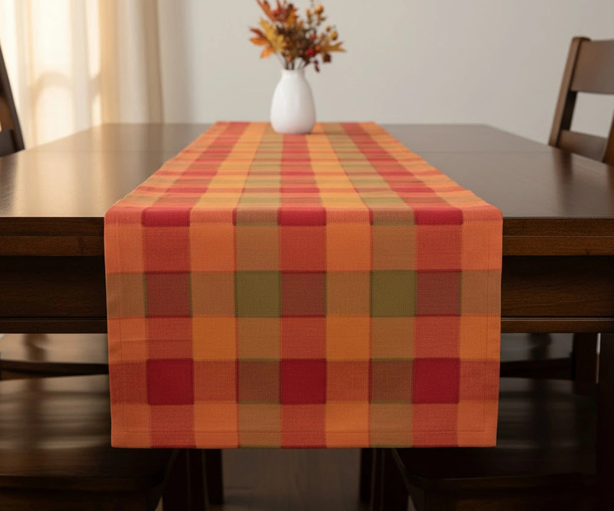 Autumn harvest plaid cotton table runner featuring warm fall tones adding cozy seasonal charm to a dining table setup.