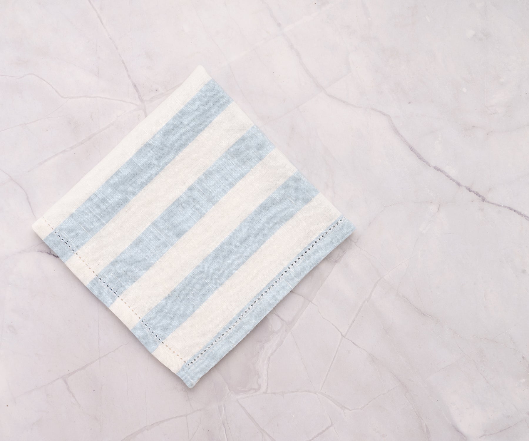 Set of pale blue cotton napkins with cabana stripe, perfect for indoor and outdoor dining.
