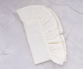 Ruffled cotton napkins layered with an embroidered tablecloth for cozy dining.