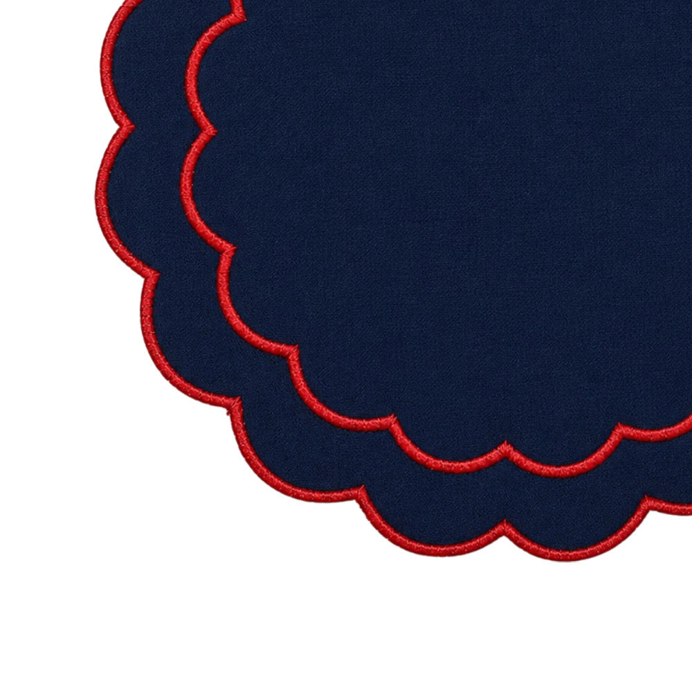 Round cotton table placemats with embroidered detailing and a decorative scalloped border