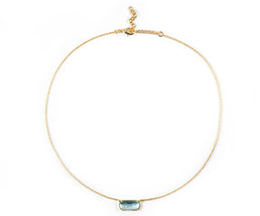 A gold necklace featuring blue stone necklace.