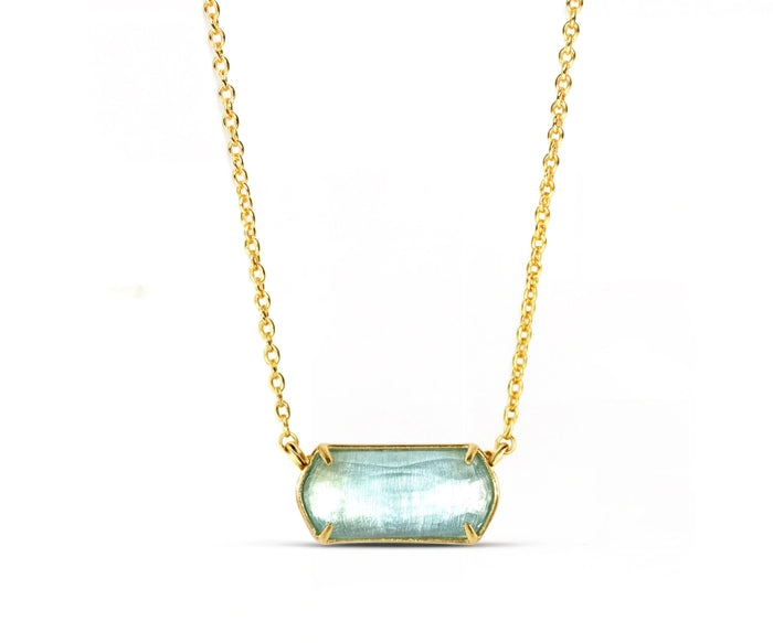 A 18k gold necklace with a blue pendant.