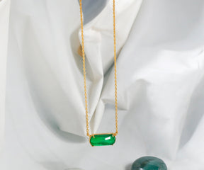 Gold chain necklace with emerald green quartz pendant.