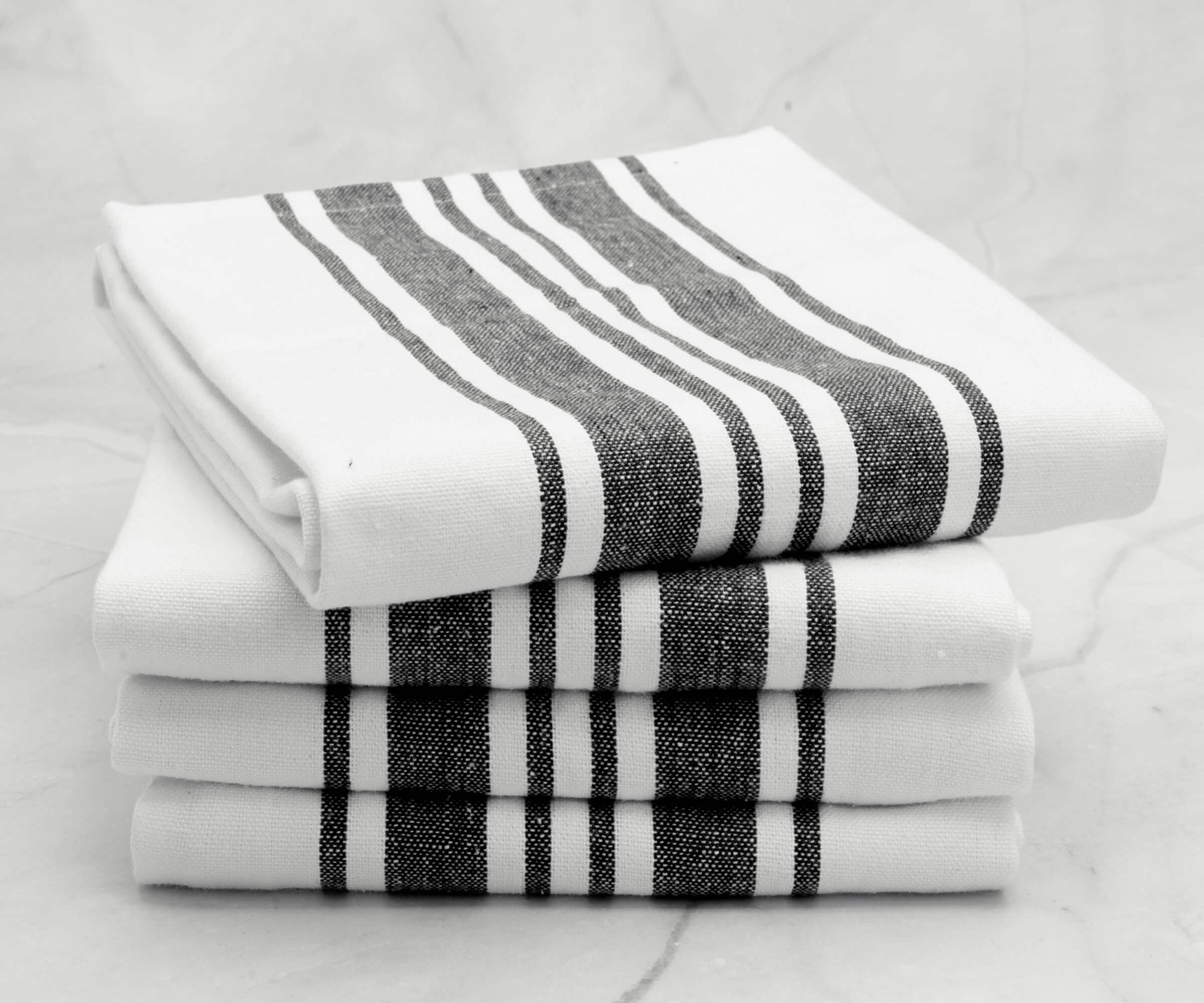 Neatly stacked black and white striped kitchen towels
