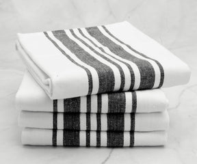 A neat stack of four kitchen towels with a black and white striped pattern