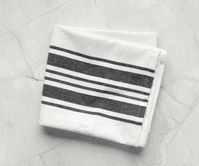Black and white striped kitchen towel draped over a marble countertop