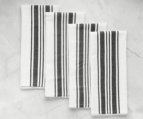 Four kitchen napkins with a bold black and white striped design