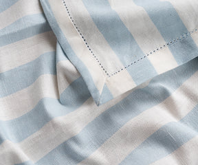 A cotton tablecloth in blue and white stripes, ideal for everyday meals and relaxed gatherings.
