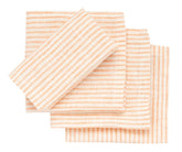 Set of striped napkins in peach and white on a white background