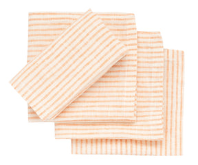 Set of striped napkins in peach and white on a white background