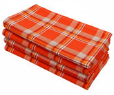 Add a cozy, rustic touch to your dining setup with tartan plaid cotton napkins in orange, red, white, and black checks.