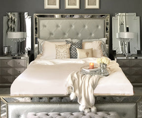 Bedroom interior with a silver bed dressed in a cotton fitted sheet and a mirror in the background