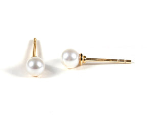 Minimalist gold and pearl earrings with push-back closure.