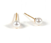 Women’s pearl stud earrings featuring classic round pearls set on delicate posts, offering a timeless and elegant accessory for any outfit.