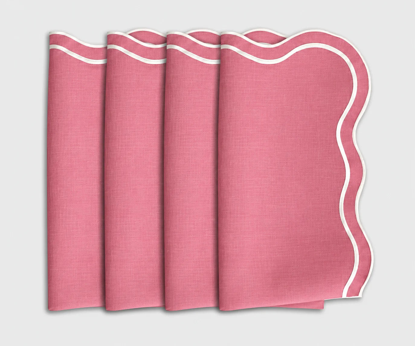 Set of 4 folded peony pink cloth dinner napkins featuring a white scalloped embroidered edge.