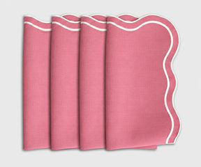 Set of 4 folded peony pink cloth dinner napkins featuring a white scalloped embroidered edge.