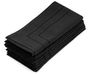Black cloth dinner napkins artfully arranged in a fan shape, bringing a touch of creative elegance to the dining table.