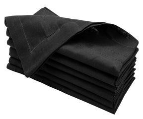 Black cloth napkins arranged on a dinner table, offering a sleek and modern look for an upscale meal.