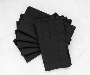 Stylish black cotton napkins displayed alongside silverware, enhancing the table's aesthetic with a chic, minimalist touch.