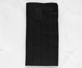 Set of black napkins folded in intricate designs, bringing an air of elegance to the dining arrangement.