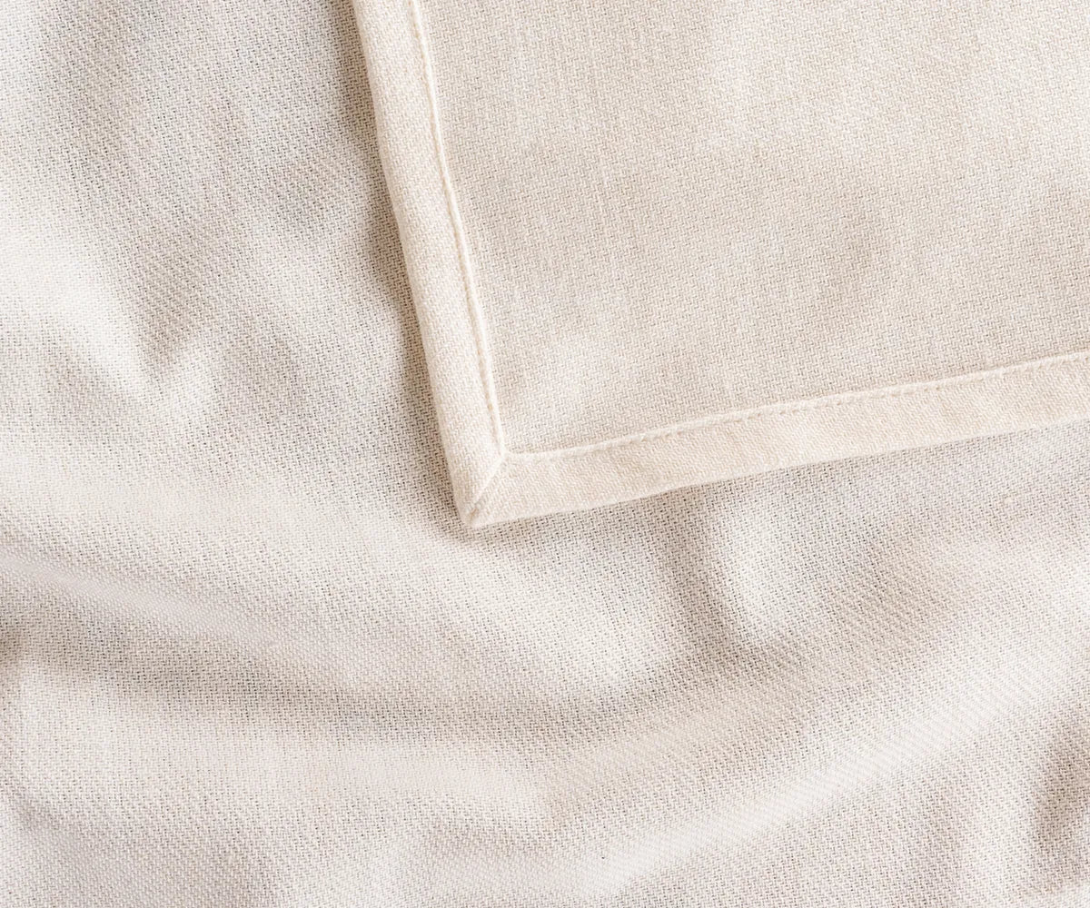 Close-up of ivory cotton tablecloth fabric showing fine weave and soft texture, highlighting breathable and durable cotton material for long-lasting use.