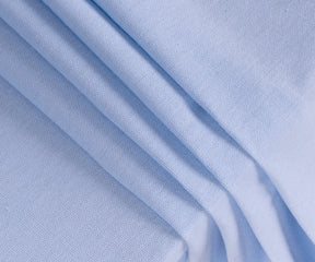 Durable sky blue cotton dining table cover displayed on a wooden table for family gatherings