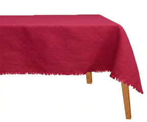 Bold red raw edge linen tablecloth draped for wedding reception and formal dinner table