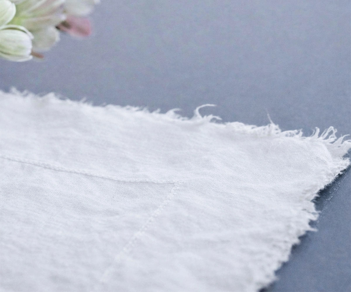 White raw edge linen tablecloth draped to floor for wedding reception and farmhouse table decor