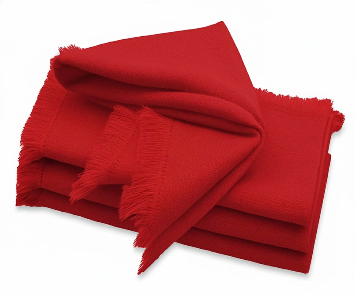 Red cotton napkin with soft fringe edges styled on a festive dining table
