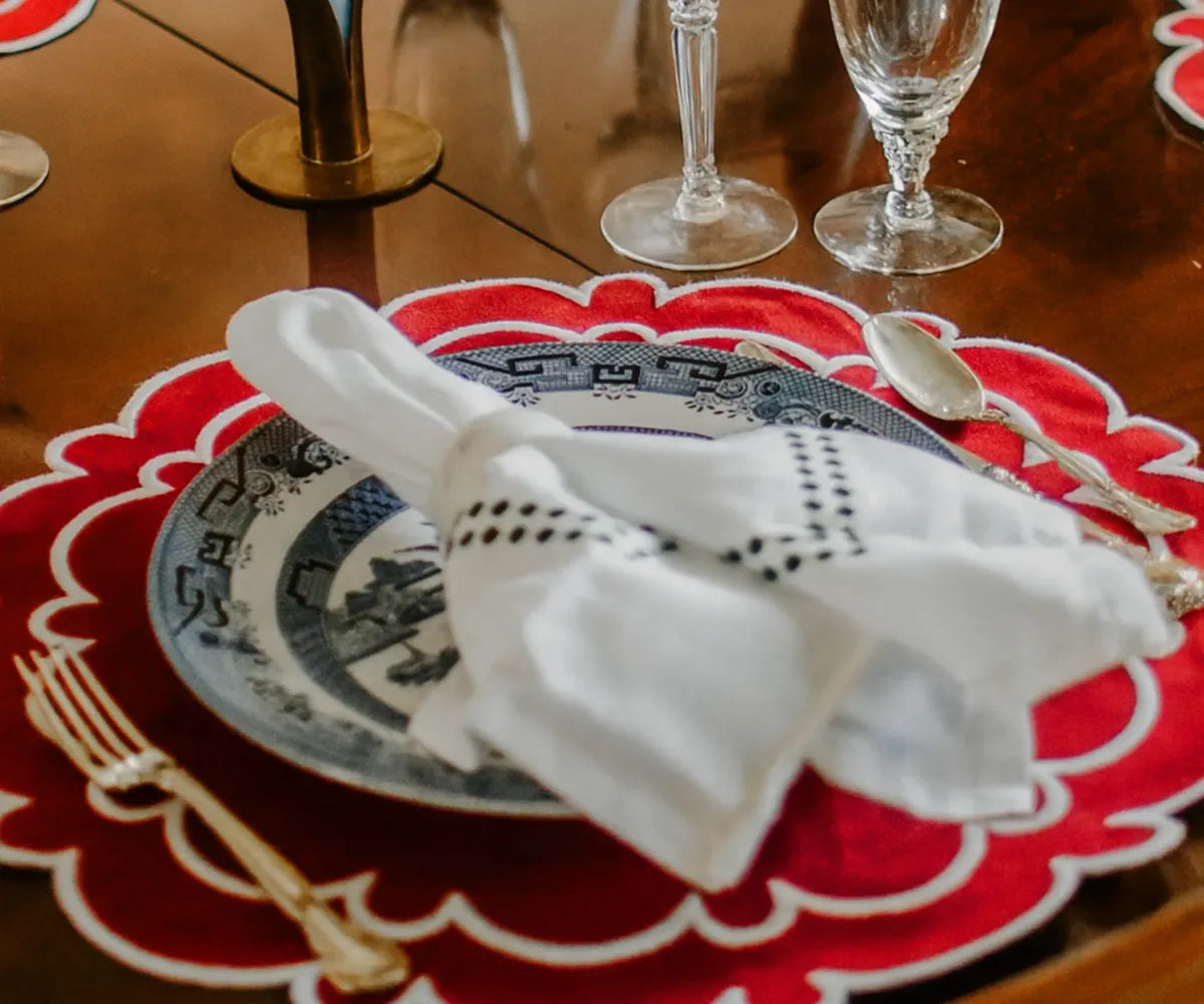 Decorative red scalloped placemats with white trim, 17-inch and 15-inch sizes.