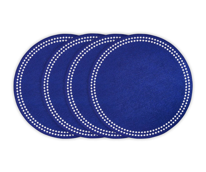 Blue cotton round placemat with white embroidered dot trim on a dining table