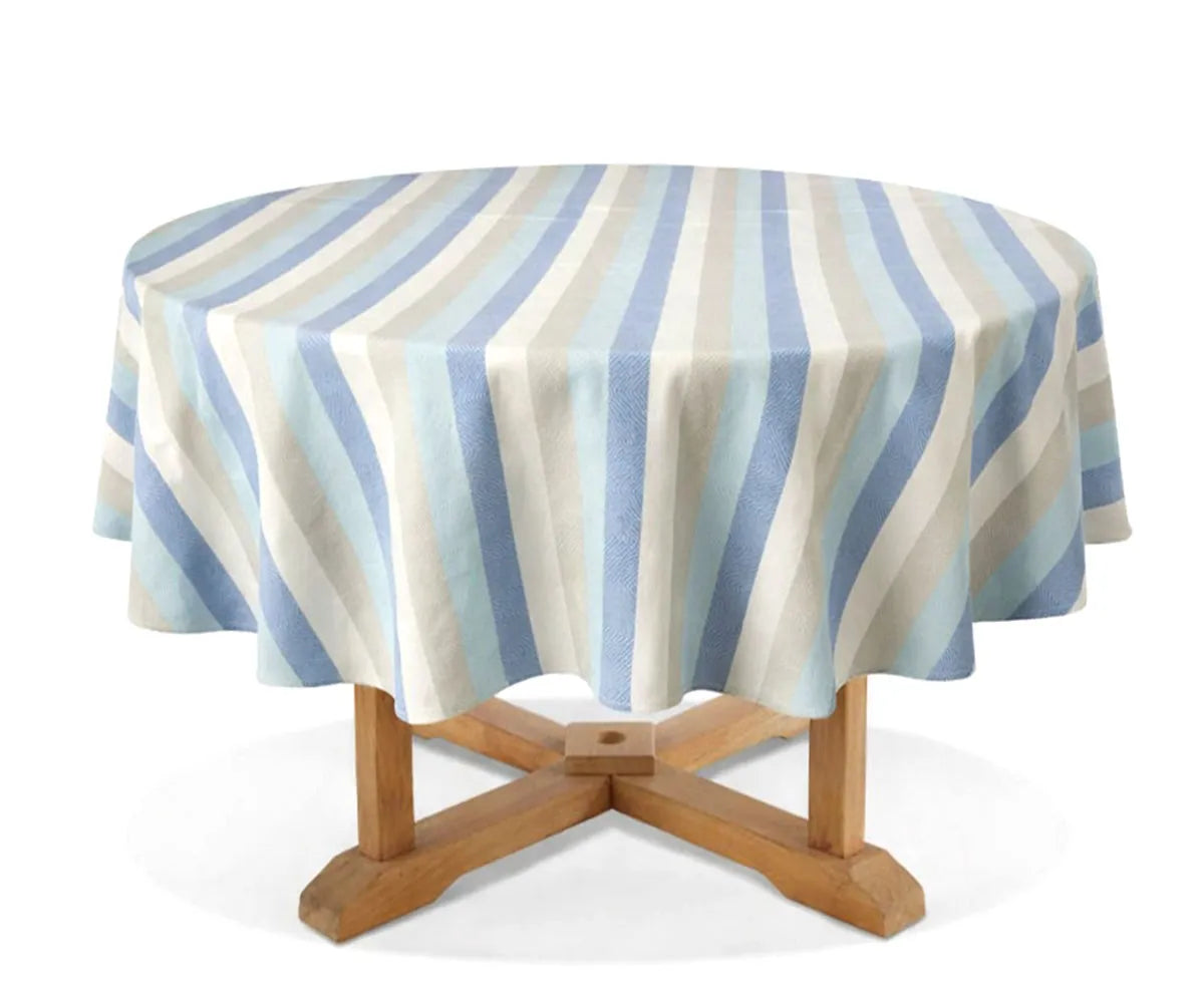 Blue and beige striped cotton round tablecloth styled on a 60 inch dining table with light blue napkins in a farmhouse setting.