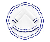 Royal blue round scalloped cotton placemats on a wooden dining table