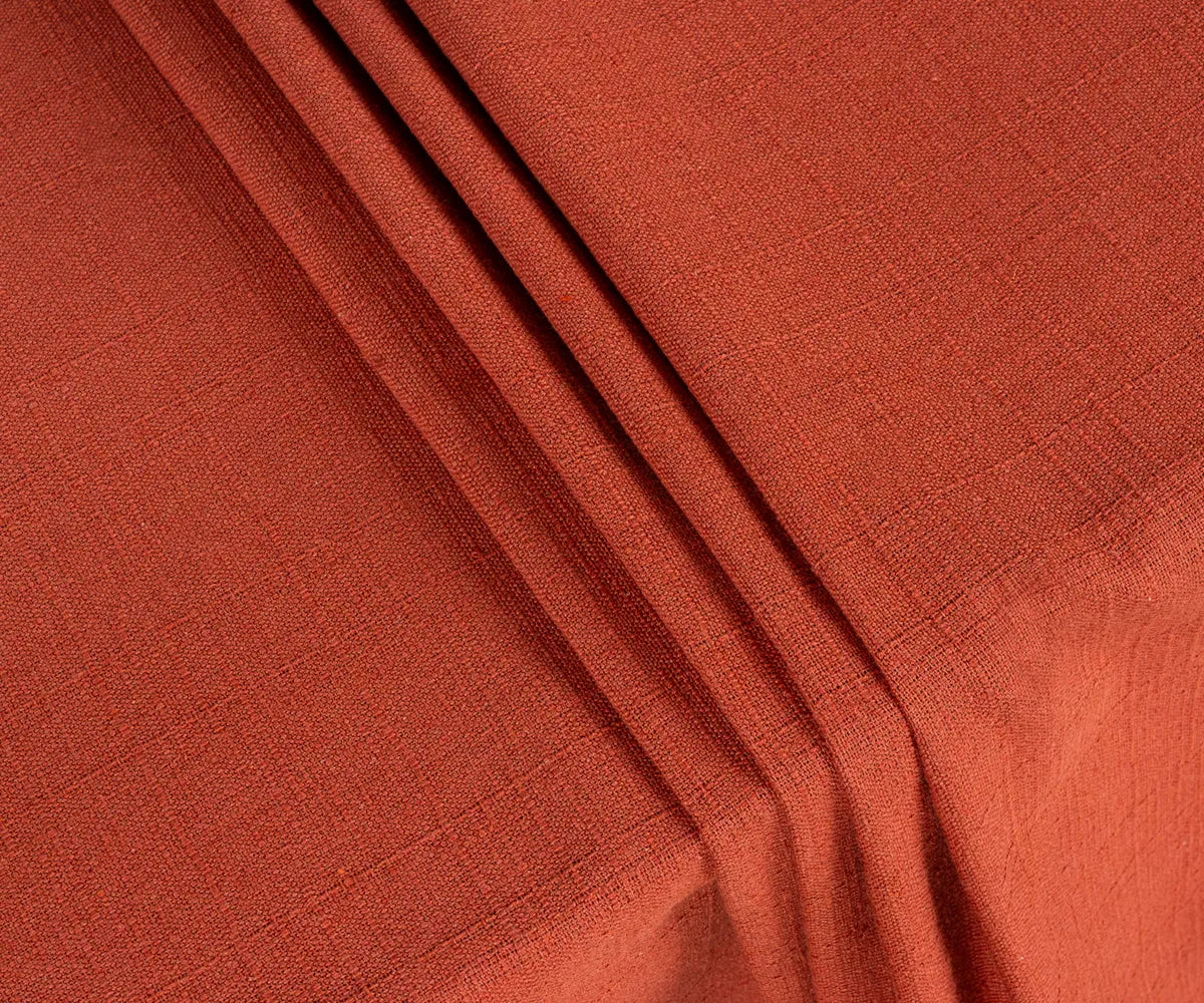 Rich rust cotton rectangle tablecloth neatly spread on a wooden table, paired with neutral runners, wooden chargers, and seasonal centerpieces for a stylish tablescape.